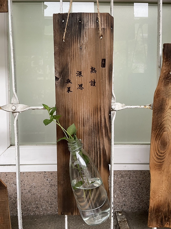學生雷雕花器作品展示於校園，瓶中綠葉點綴，營造出自然樸實的氛圍。